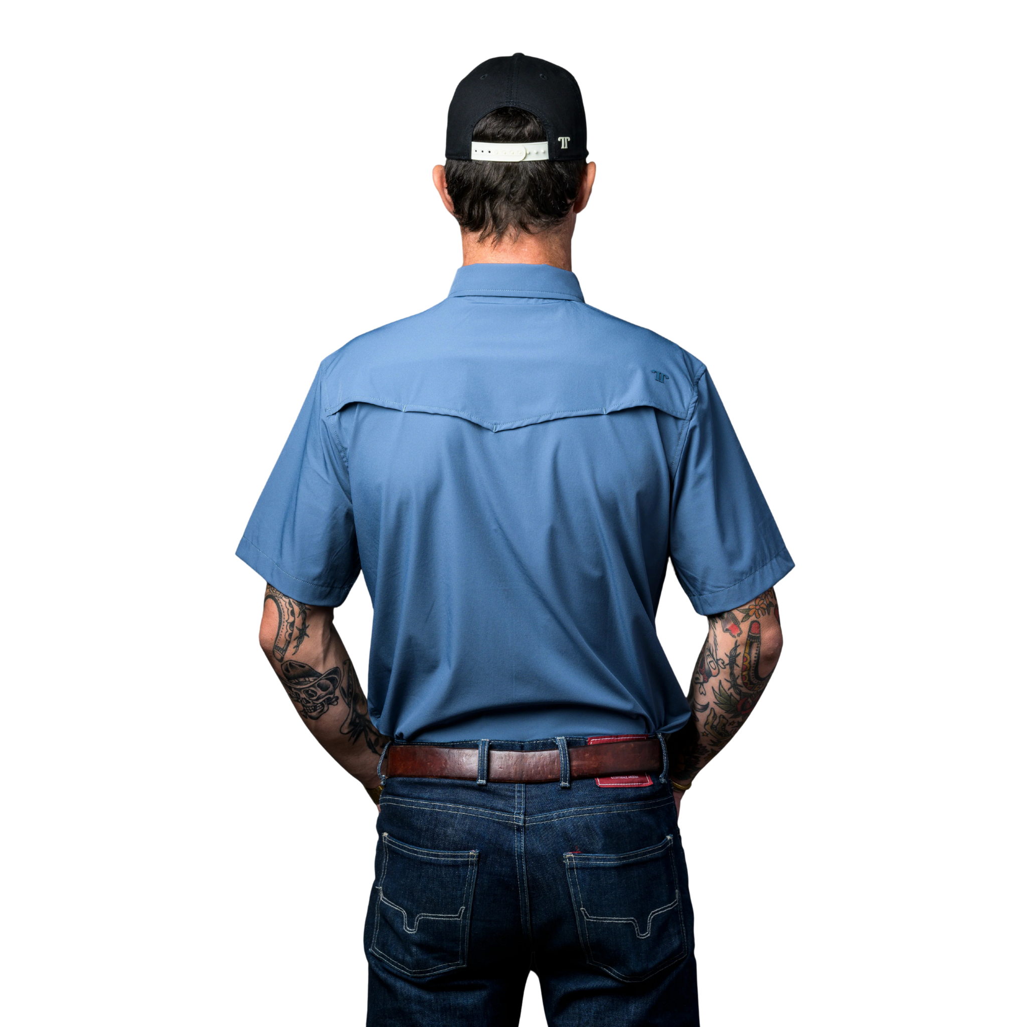 Back view of a Man wearing a blue work shirt and jeans with a black cap on a white background