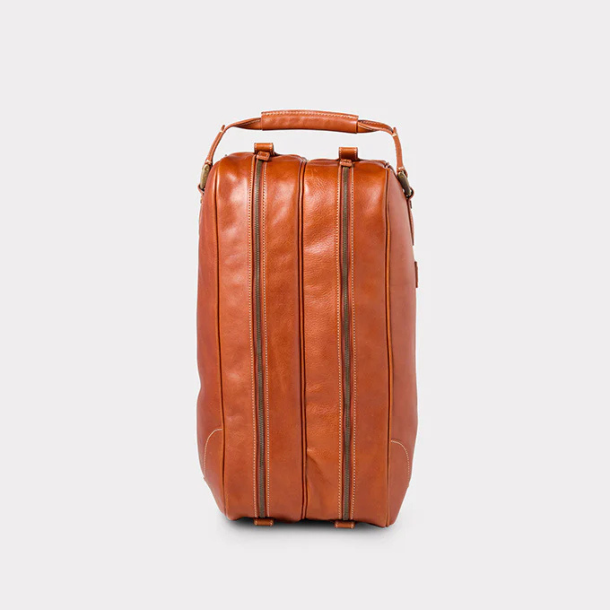 Side view of a Brown leather boot bag on a light gray background