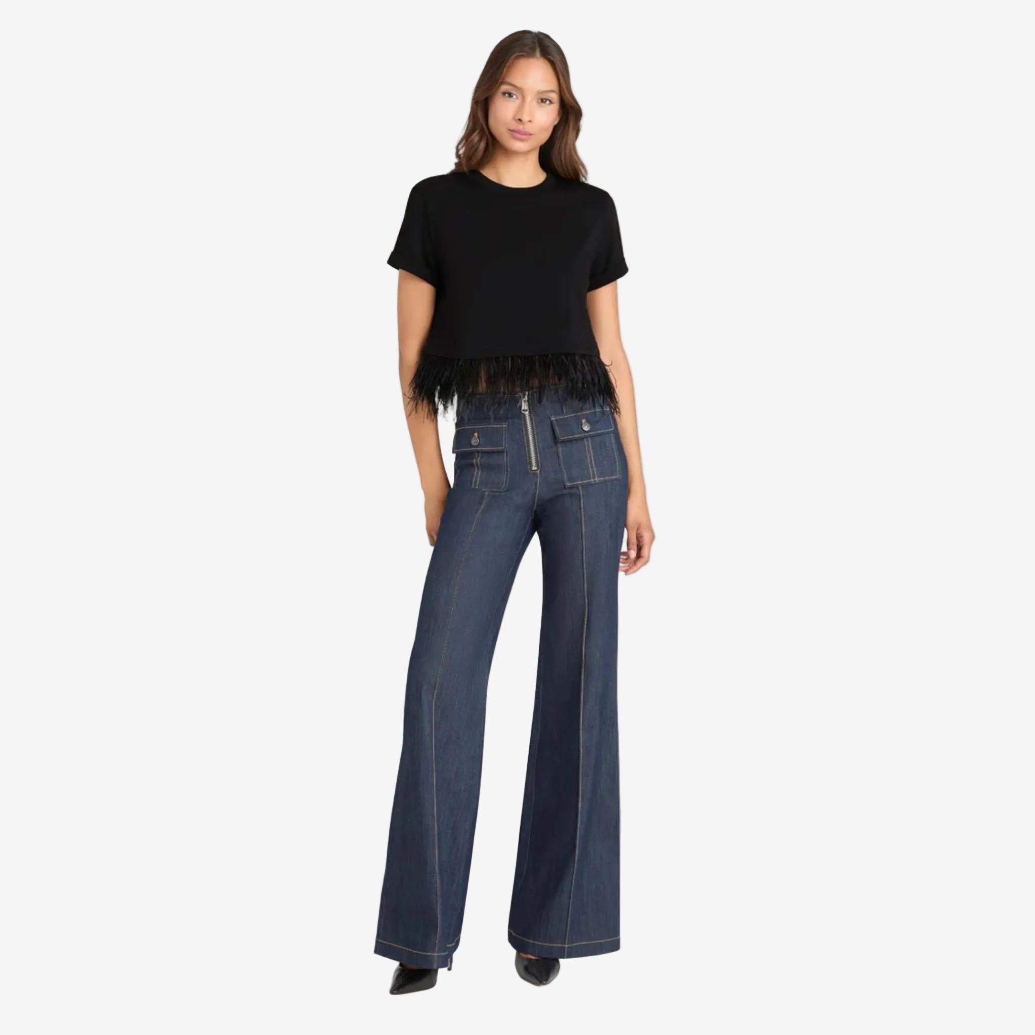 Black short‑sleeve top with a cropped silhouette and a fringe hem, paired with high‑waisted dark denim wide‑leg pants featuring contrast stitching, a front zipper, and large flap pockets.