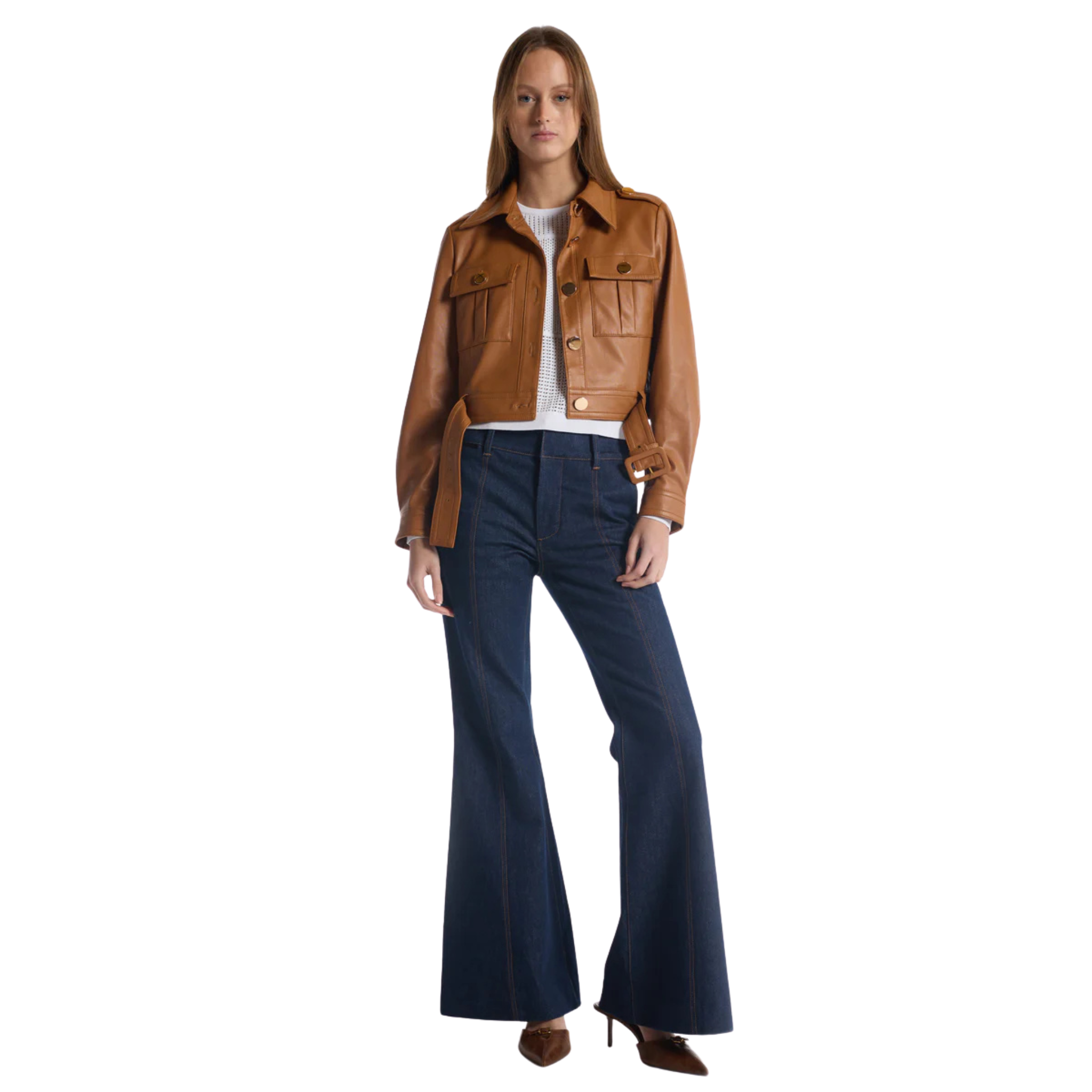 Model wearing a cropped tan leather jacket with front flap pockets and a belted waist, paired with a white textured top, dark wide‑leg denim pants, and pointed‑toe heels.