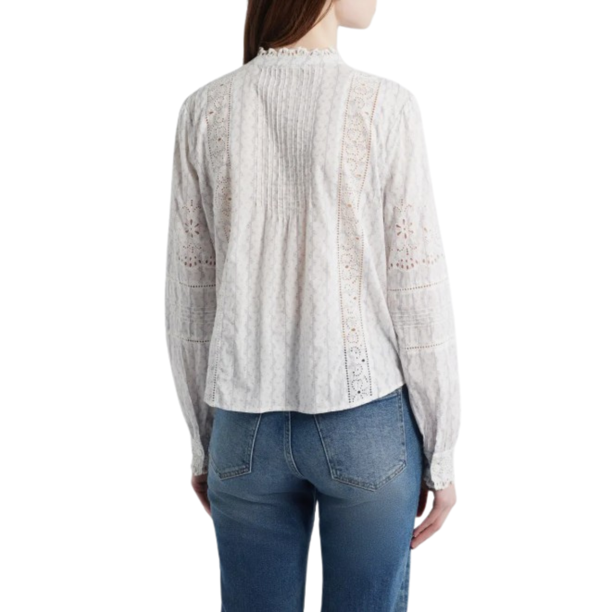 Model wearing a white long‑sleeve lace blouse with delicate eyelet detailing, a ruffled mock neckline, button‑front closure, and paired with medium‑wash jeans.